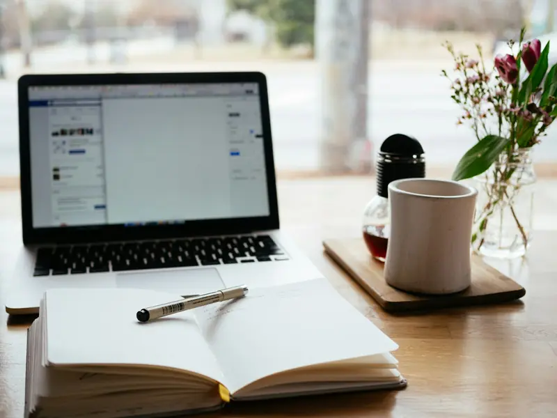 A notebook next to a laptop